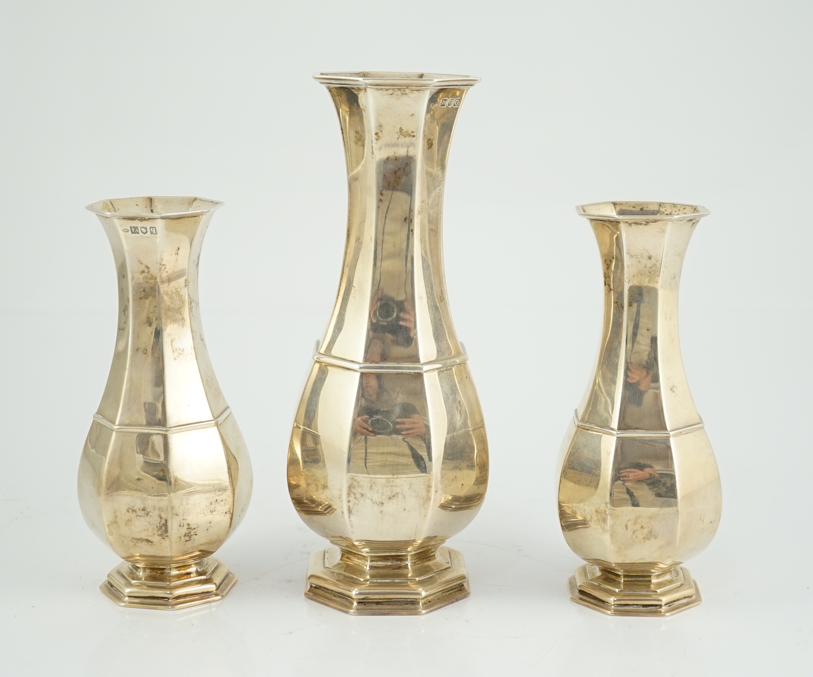 An Edwardian garniture of three panelled silver baluster vases by William Comyns